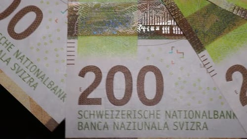 Several 200 Swiss franc banknotes rotating. Detail shot with security features. Close up rotating sh