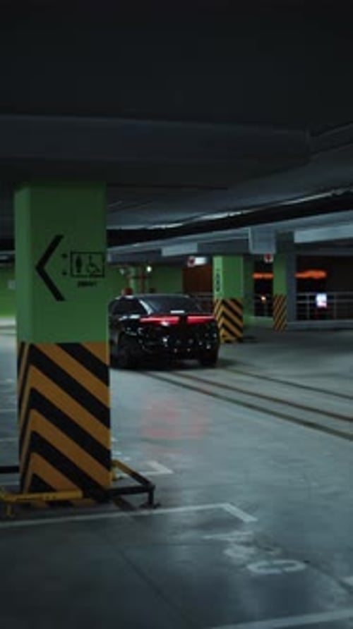 Black Electric Car Driving Through Underground Parking Garage