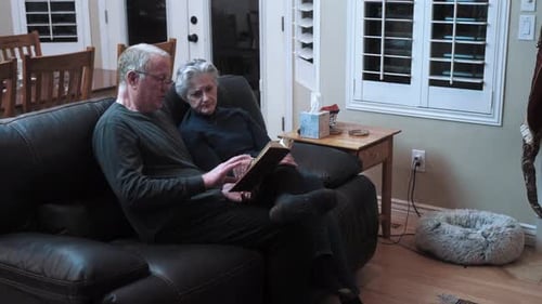 Senior old coupled reading a book together