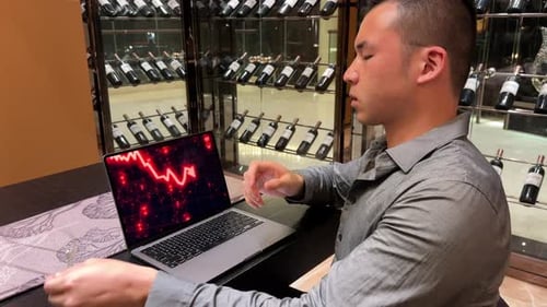 Stressed Asian Millennial Man Looking at Stock Market Crash on Computer Screen Due to Economic Reces