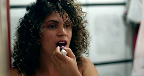 Woman Applies Lipstick and Checks Curly Hair in Mirror