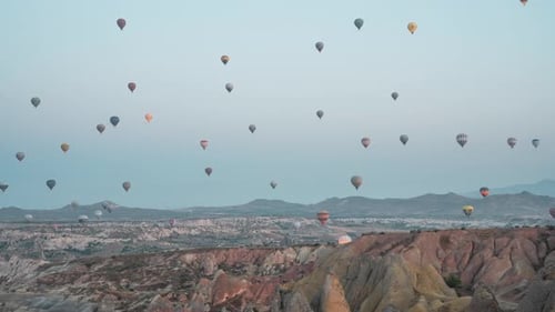 Hot air balloons fill the sky at dawn over the rocky landscape of Cappadocia, Turkey, timelapse