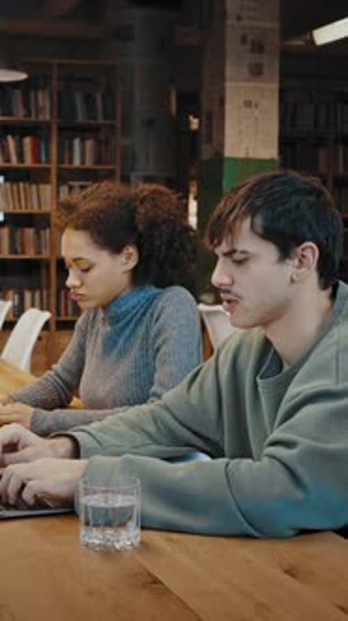 Concentrated Diverse Millennial Students Work with Information at Public Library