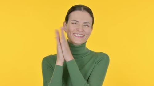 Woman Smiling and Clapping on Yellow Background