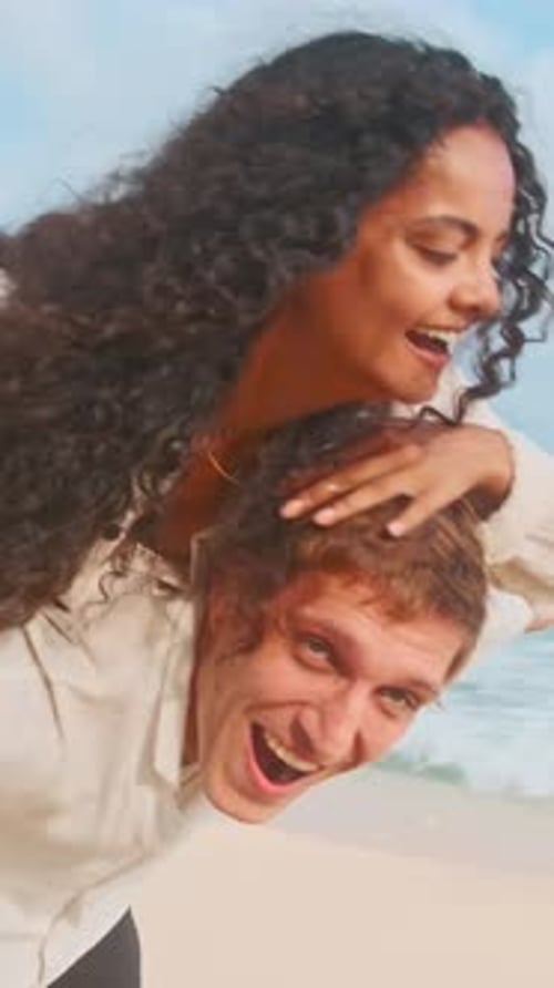 Happy Couple Enjoying Beach Playtime Together in Sunny Weather