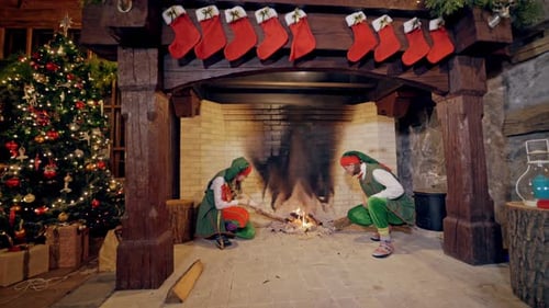 Elves near fireplace on Christmas background indoors.