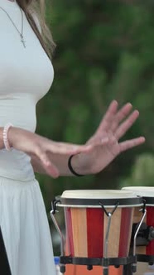 Woman Playing Percussion on Bongo Drums Outdoors