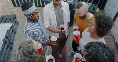 Multiracial Group of Young People Friends Clinking Cups and Drinking Enjoying Celebration at Open