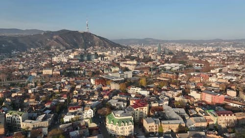 Aerial panoramic view of Tbilisi, Georgia, with the Kura River, city center, and Mount Mtatsminda