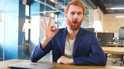 Bearded Man Gives OK Sign in Modern Office