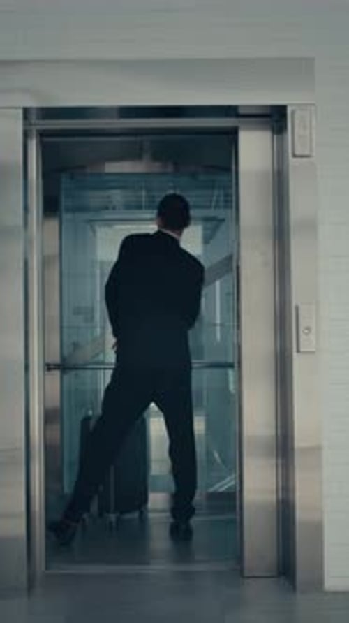 Man with Suitcase Dancing in Elevator