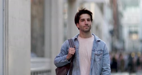 Young adult male walking down street
