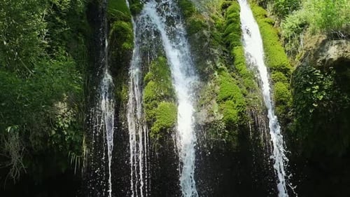 Magical mountain waterfall, crystal water, large stones overgrown with moss. The waterfall with the