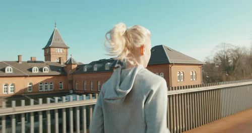 Young woman sprinting on empty road under sunny sky for fitness training
