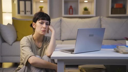 Portrait of sad young woman at night at home.