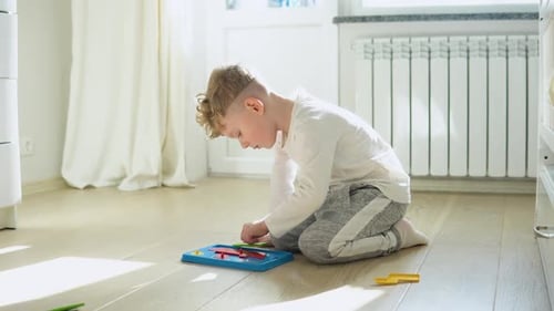 Little Boy Playing Education Toy on the Floor in Nursery