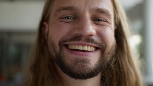 Man with Long Hair Smiling and Looking at Camera