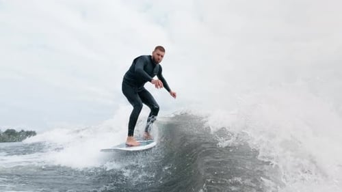 Man Wake Surfing in the Ocean on Overcast Day