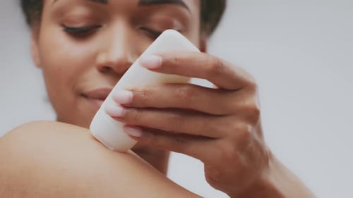 Woman Applying Cream to Arm in Close Up