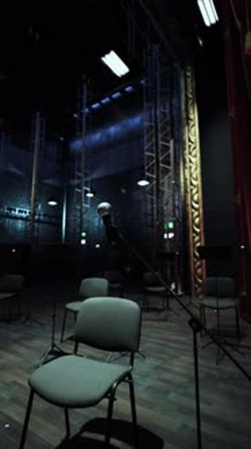 Dark Empty Stage with Chairs and Microphones