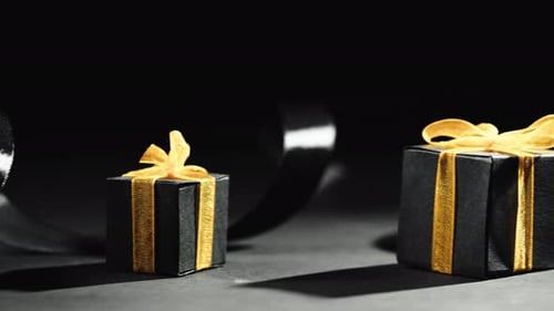 Gift Boxes with Gold Ribbons on Black Background