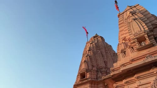 Un temple hindou avec un drapeau hindou rouge flottant au sommet