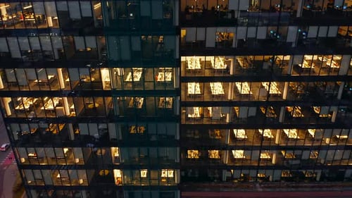 Cinematic Drone Shot of a Glass Facade of an Office Building Night