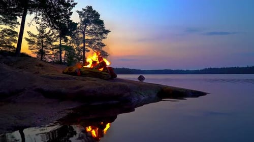 A Cozy Campfire Burns on a Rocky Lakeshore