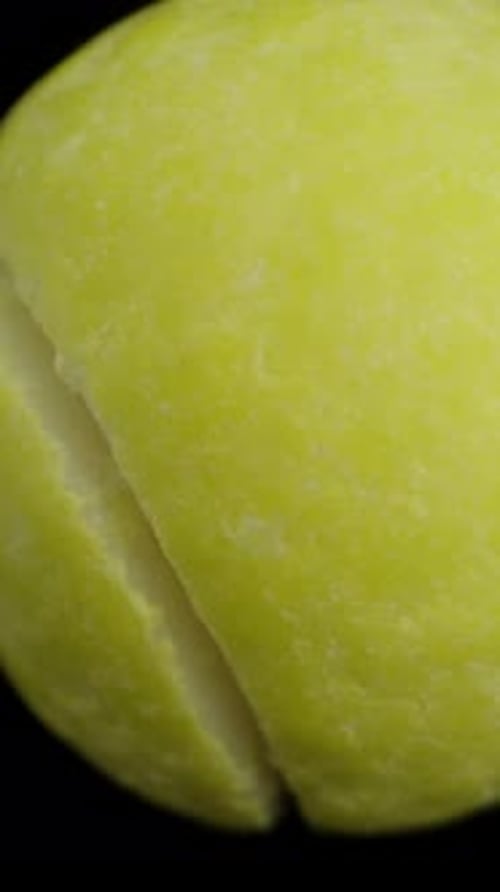 Textured Yellow Ball Slowly Splits Apart on Black