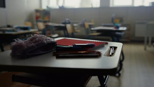 Material escolar de primer plano en los pupitres escolares. Lápices, bolígrafos y cuaderno sobre madera