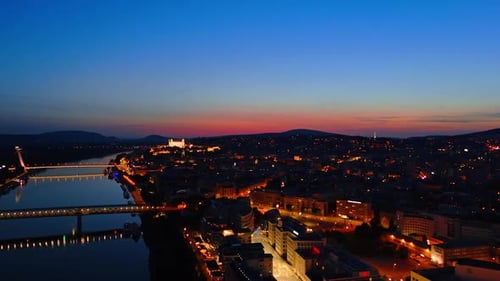 Beautiful illumination of old town in Bratislava, Slovakia. Drone footage above the Danube at night.