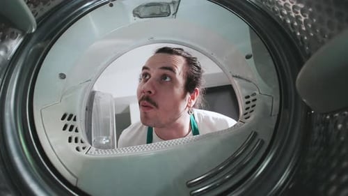 Man Loading Clothes Into Washing Machine, Inside View