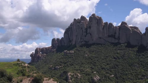 Lush green Montserrat mountain rock ridge aerial dolly right across impressive Spanish mountain attr