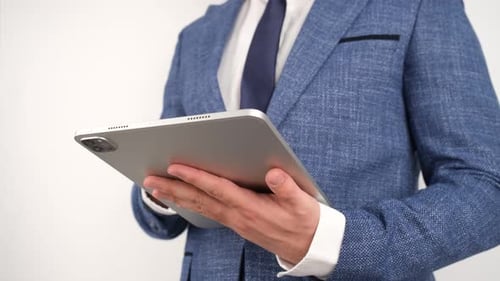 Man in Suit Holds Silver Tablet