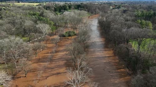 Overhead view of flooding. High water level theme. Aerial above river with bare trees in winter in U