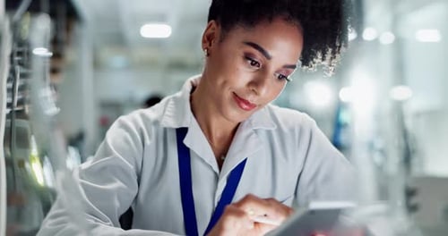 Woman in Lab Coat Using Tablet in Laboratory