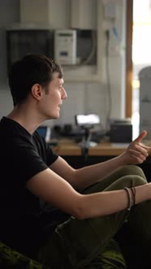 A Young Man in a Home Office Has a Casual Conversation Displaying a Modern Lifestyle