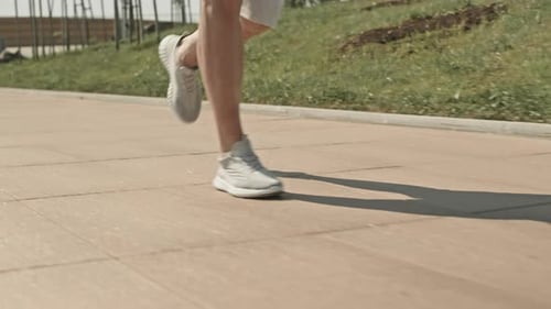 Legs of Man Running along Street