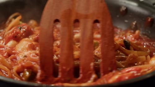 Pasta being Stirred with Red Sauce in Pan