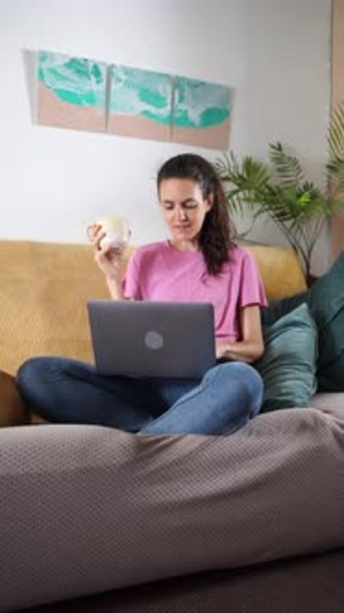 Woman Enjoying Coffee While Using Laptop at Home