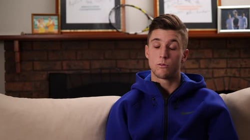 Young Adult Male Sits and Talks on Couch