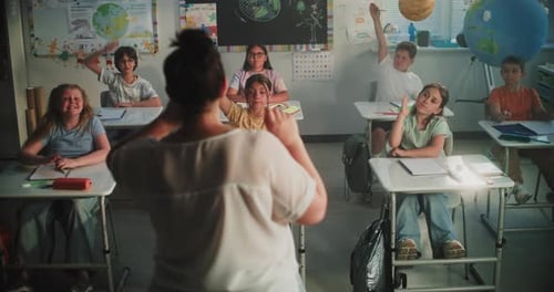 Enthusiastic Elementary Students Raising Hands in Classroom