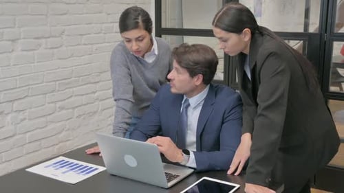 Team Collaborating on Laptop in Modern Office