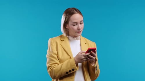 Young Woman Using Smartphone on Blue Background