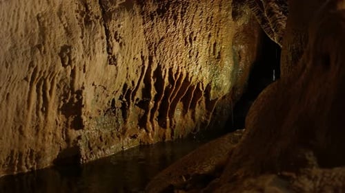Water Reflecting in Colorfully Lit Underground Cave