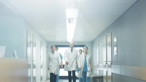 Team of Doctors, Nurses and Assistants Walking through the Hallway of the Hospital. Professional Me