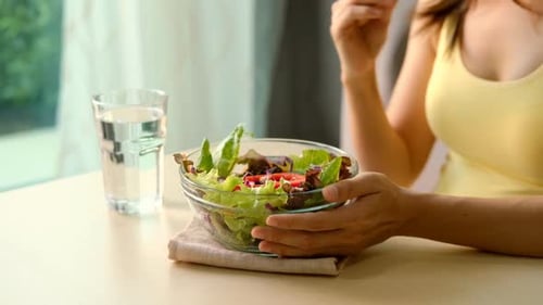 Woman Eats Healthy Salad at Indoor Table