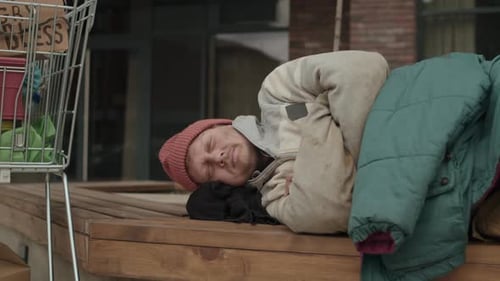 Homeless Person Sleeping on a Bench in City