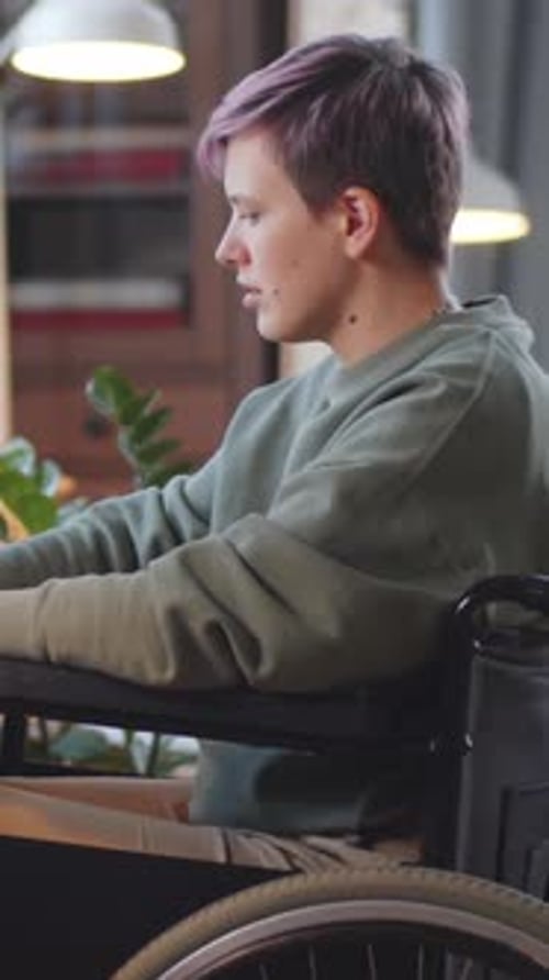 Young Adult in Wheelchair Smiles Indoors