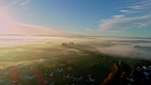 Breathtaking rural Germany landscape aerial drone in 4k. Fog over fields and town at sunrise.